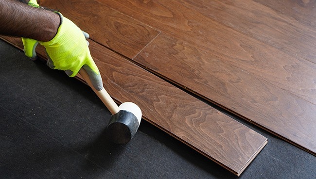 Worker installing hardwood floors | Floor Systems