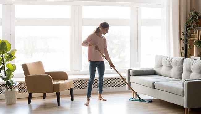 Young woman housewife clean wash hardwood floor in modern living | Floor Systems