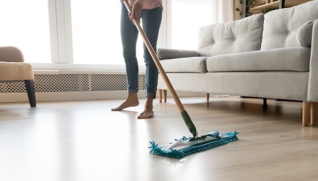 Young woman in casual clothes washing heated wooden laminate | Floor Systems