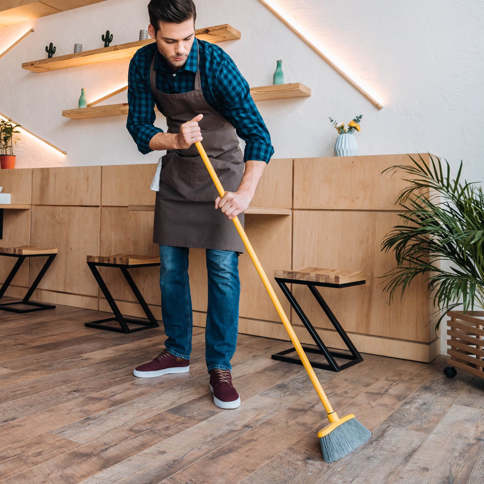 Man sweeping hardwood floor | Floor Systems