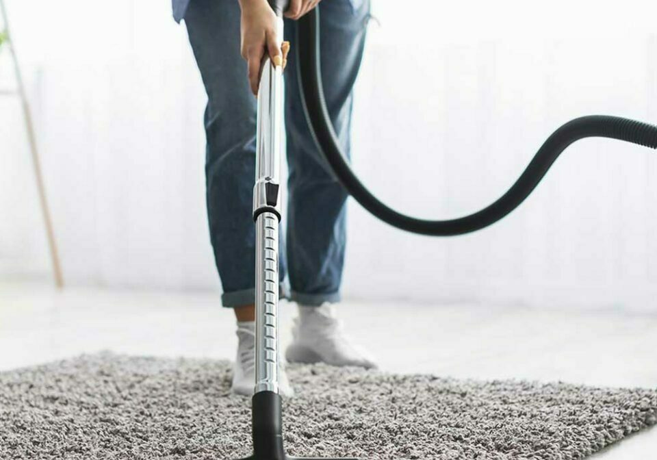 Person vacuuming rug | Floor Systems